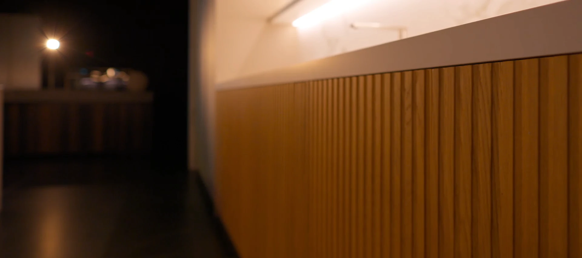 Fluted oak cabinet front in low light, from a DOCA film