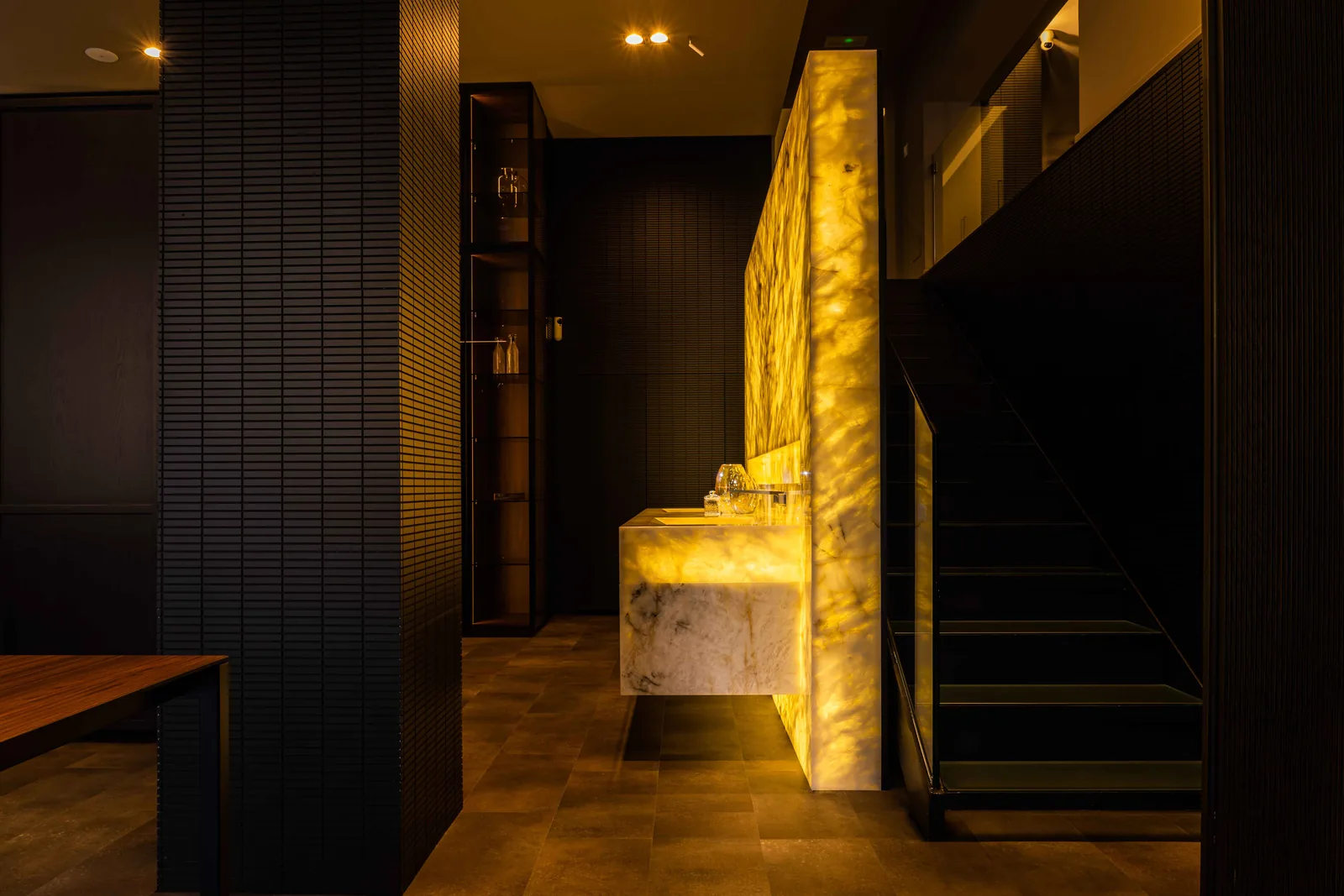 Back-lit stone vanity beside a glass display in DOCA's Madrid showroom