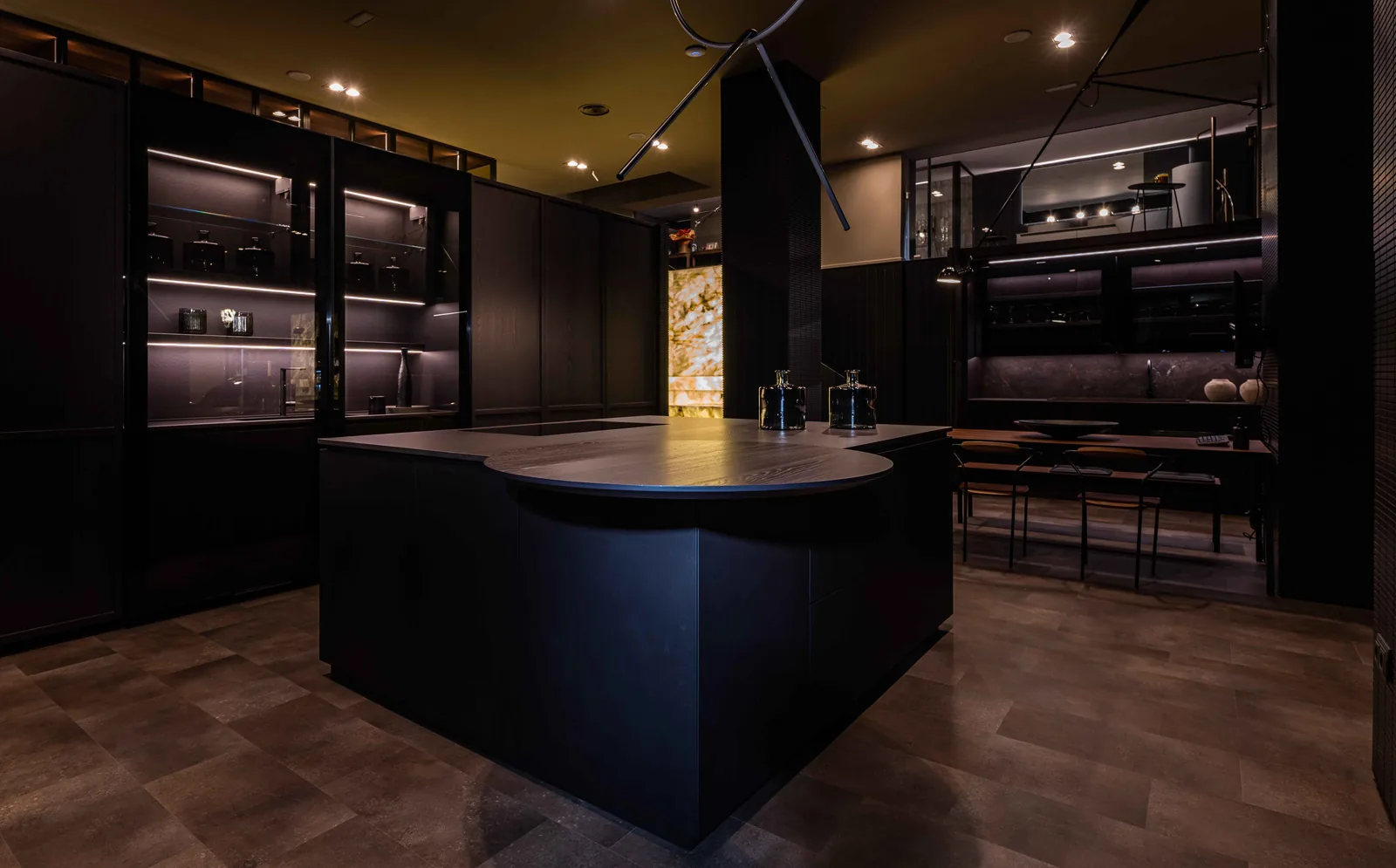 Dark kitchen island with a round wood top in DOCA's Madrid showroom