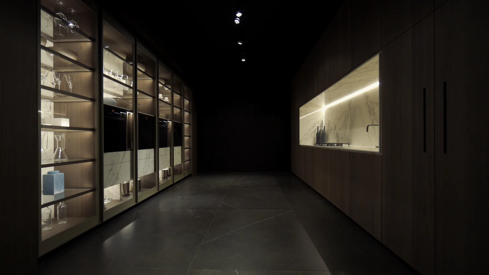Lit glass-front tall cabinets and a stone niche in a DOCA showroom