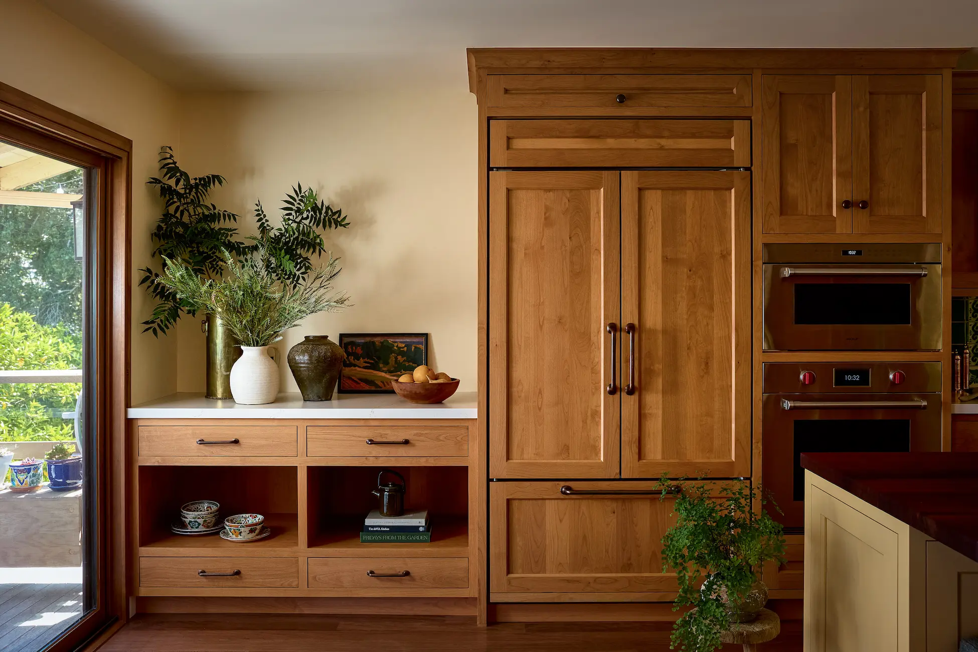 Warm wood Crystal kitchen with paneled appliances and open shelving