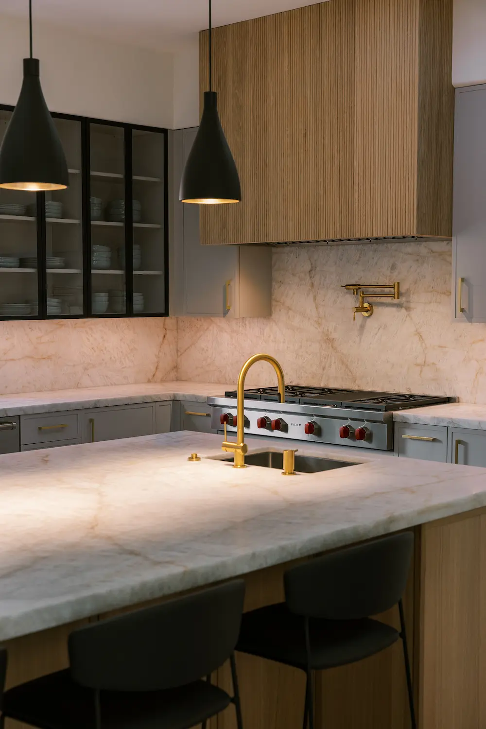 Brass faucet on a veined stone island facing an oak range hood and pot filler