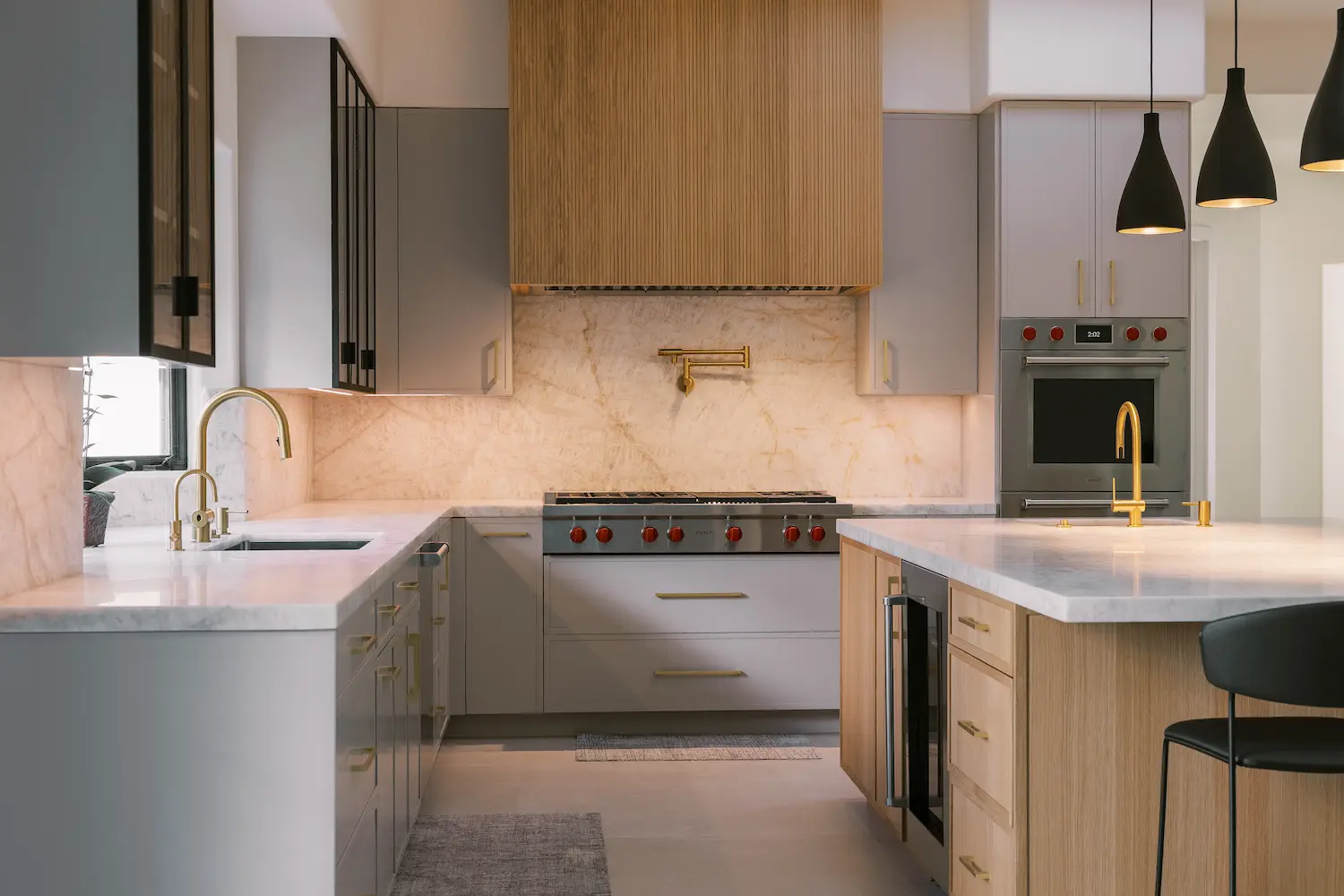 Gray perimeter cabinets and an oak island framing a range under an oak hood