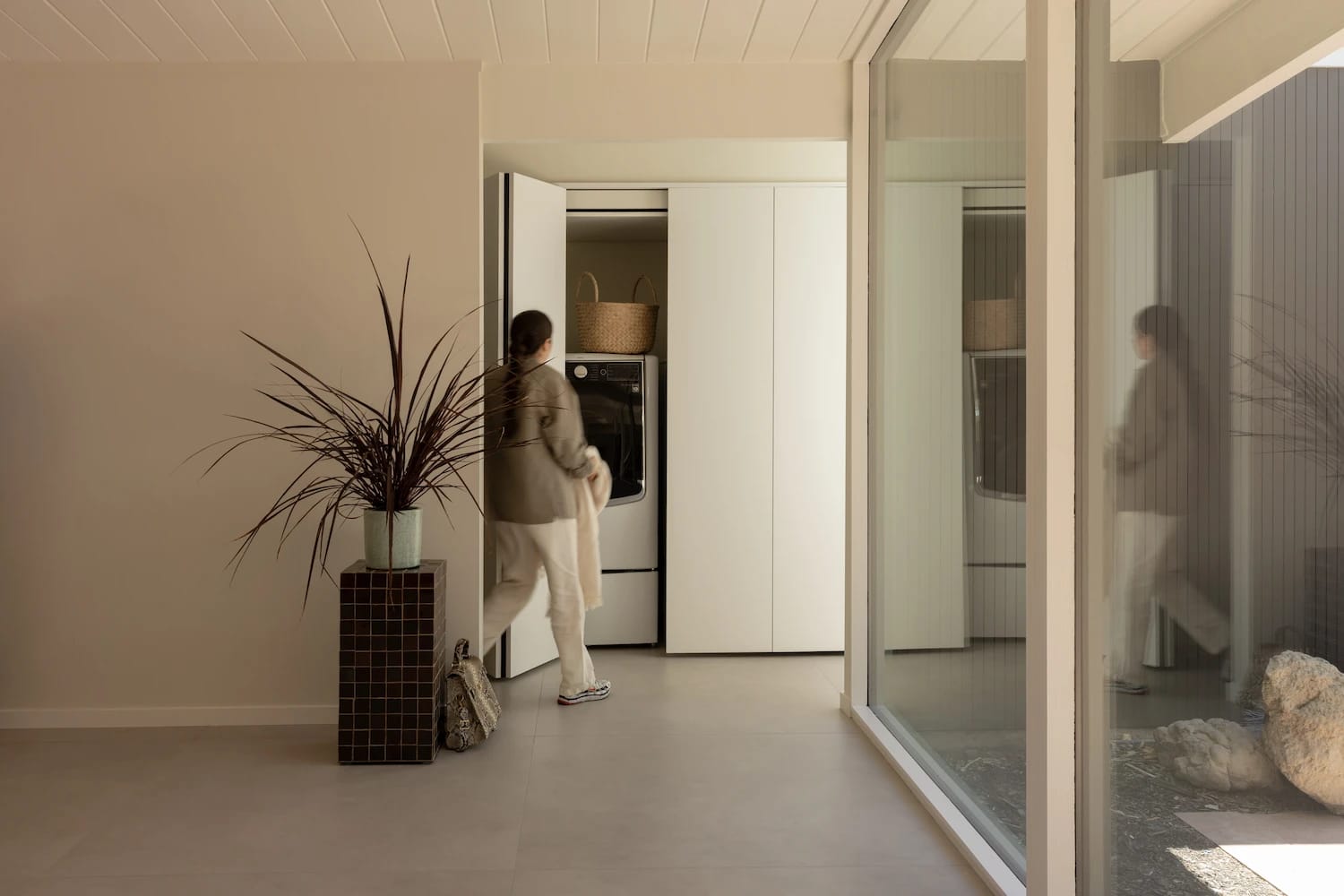 White laundry closet with folding doors off a bright Eichler hallway