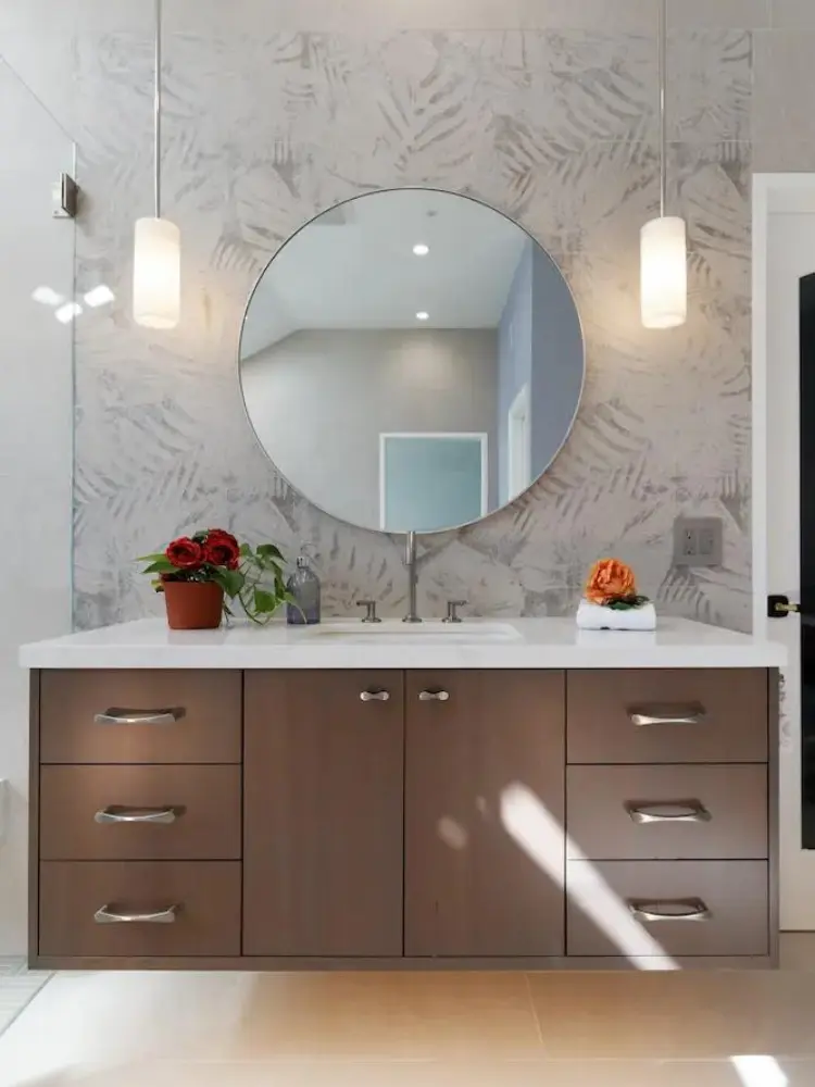 Contemporary bathroom with floating wooden vanity, round mirror, and pendant lighting