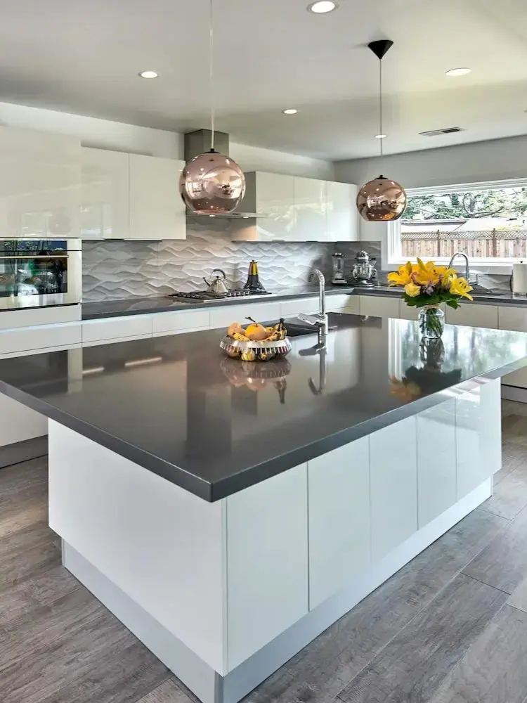 Modern kitchen with a large island, textured backsplash, and pendant lighting