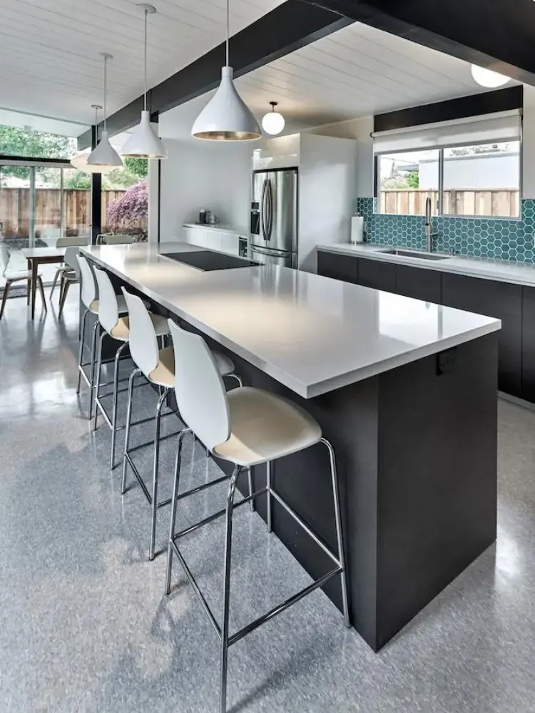 Mid-century modern kitchen with a large island, pendant lighting, and minimalist design elements