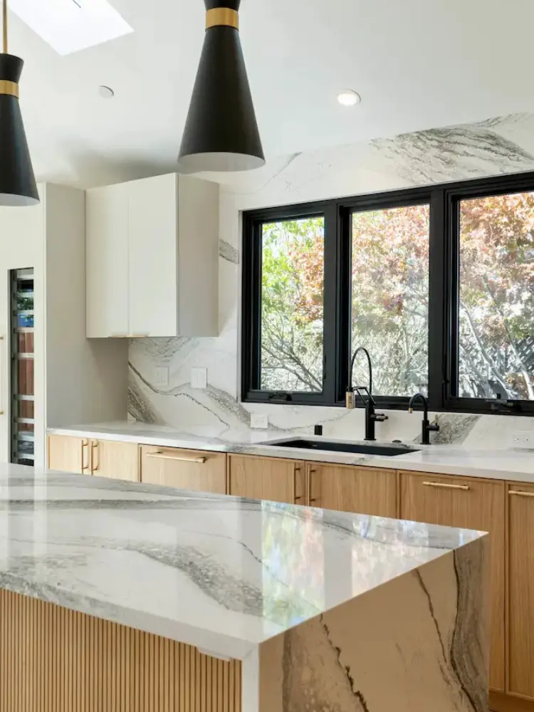 Contemporary kitchen design with white Cambria quartz countertops and natural wood cabinetry by Doca