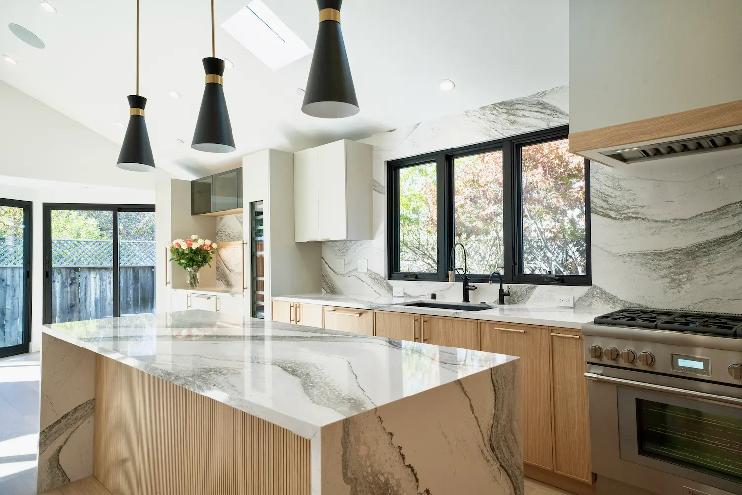Modern kitchen featuring black fixtures, natural wood finishes, and Cambria quartz countertops for a cohesive design