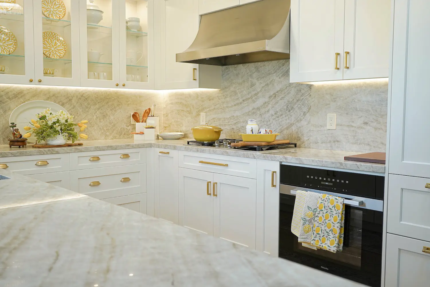 High-end kitchen corner featuring marble countertops, gold drawer pulls, and under-cabinet lighting for a sophisticated finish