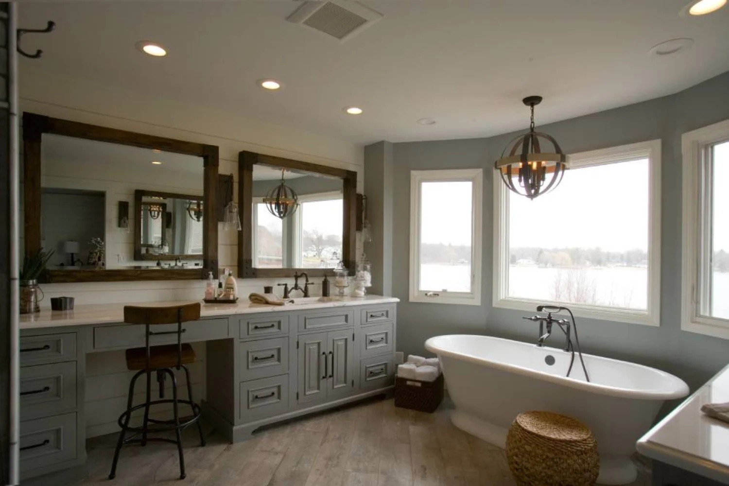 Lakeview bathroom with rustic-style vanity, round soaking tub, and oversized windows overlooking the water