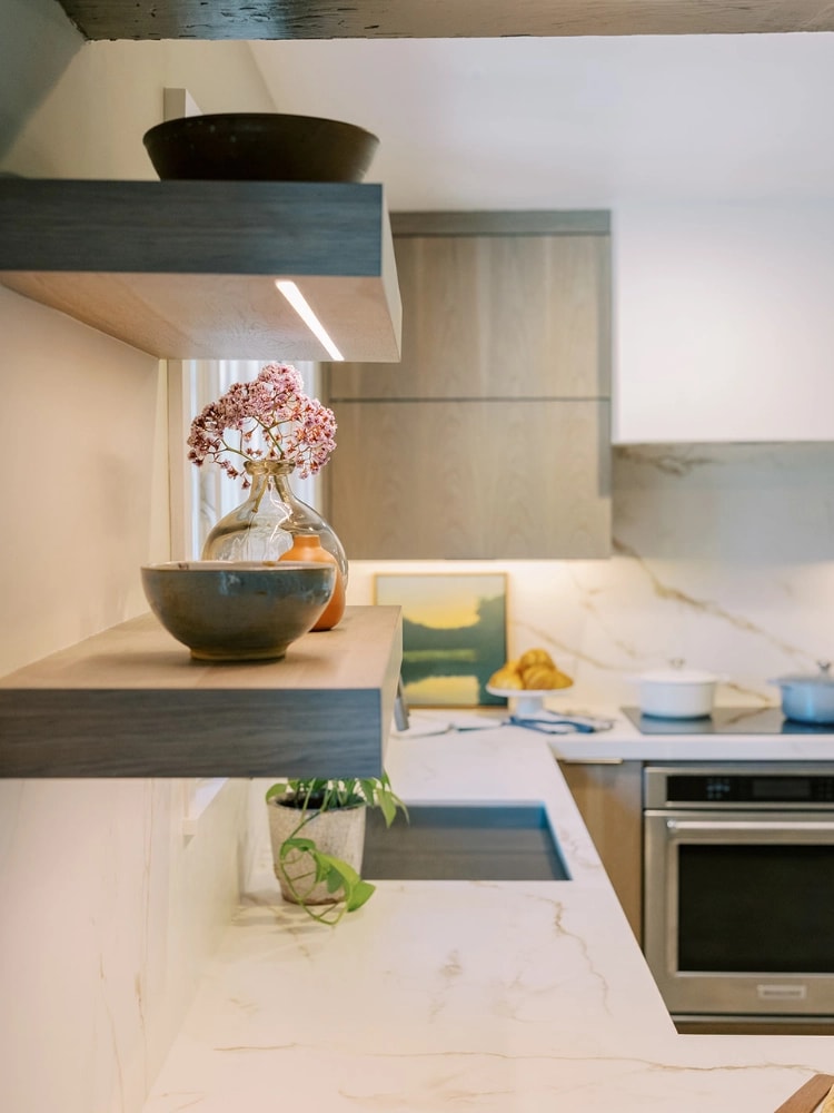 Editorial kitchen perspective with open shelving, matte black sink, and a blend of earthy decor and contemporary cabinetry