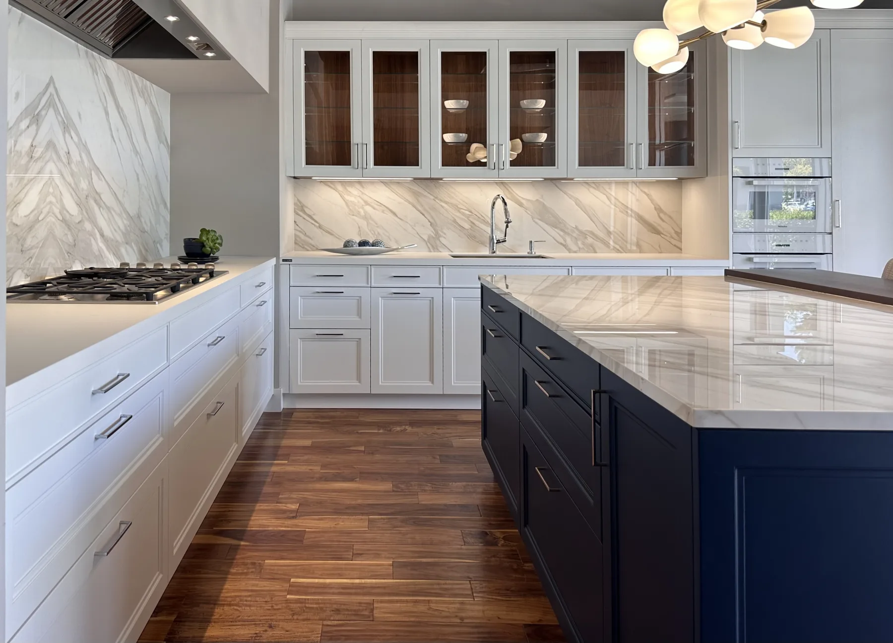 White and navy kitchen display with marble countertops inside the Artistic Kitchen showroom in Mountain View