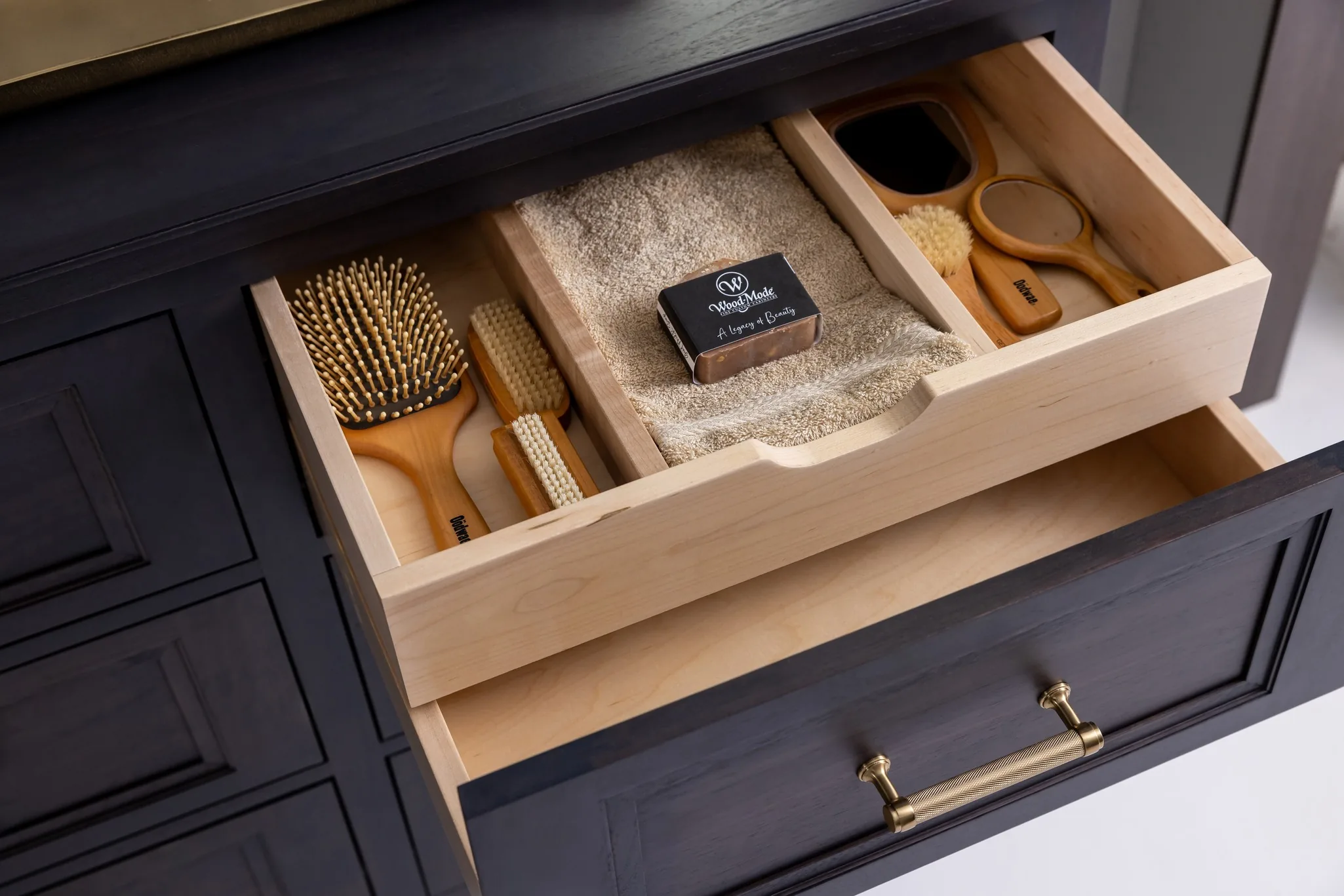 Open Wood-Mode drawer with a fitted wood insert holding brushes