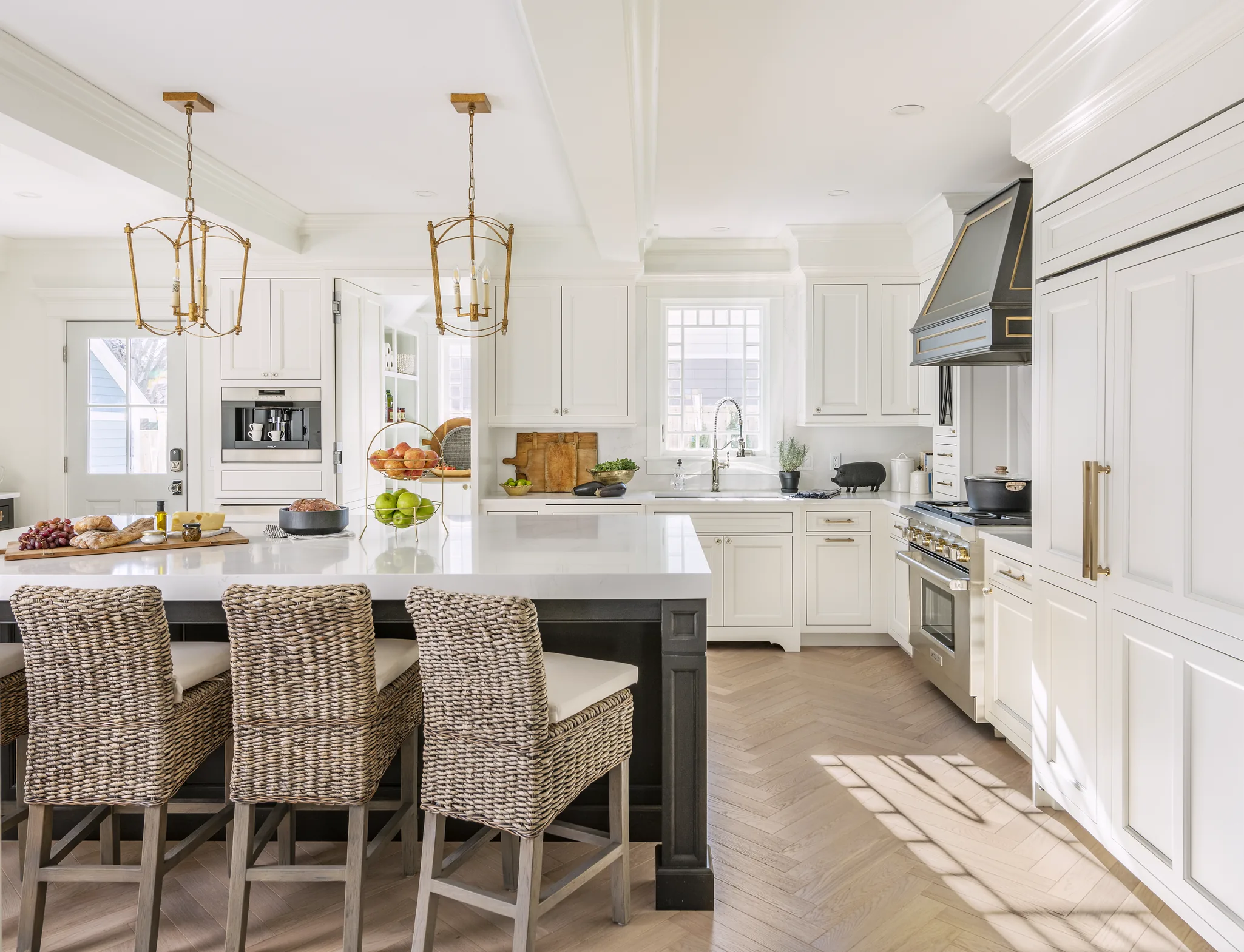 Bright white Wood-Mode kitchen with a large island and woven stools