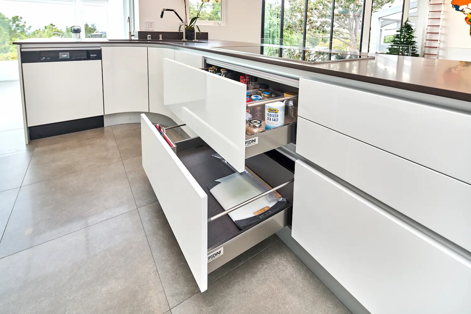 Sleek kitchen with modern drawer storage, featuring a white high-gloss finish and integrated handles for a seamless look, along with ample countertop space