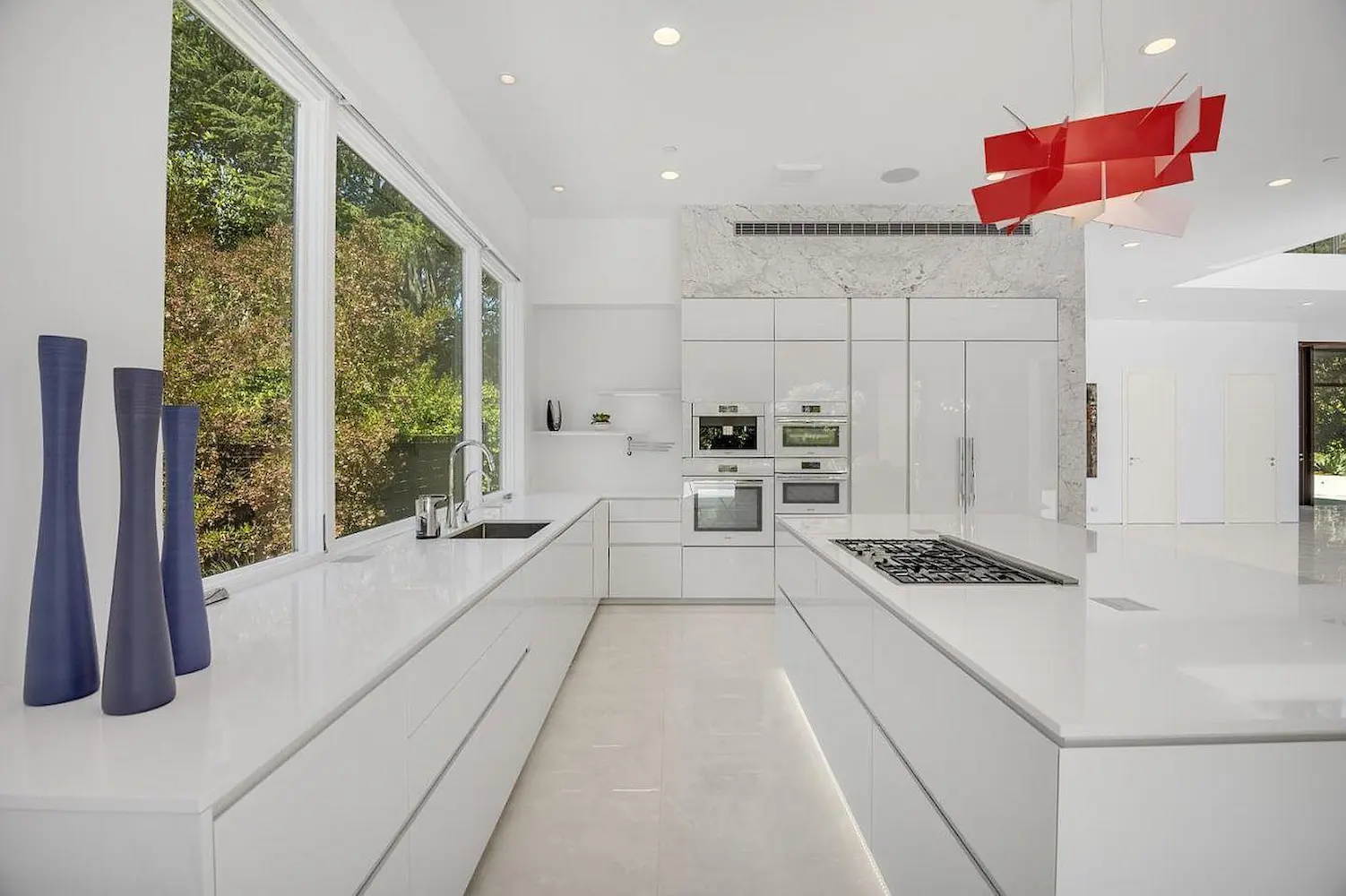 a white kitchen with large windows